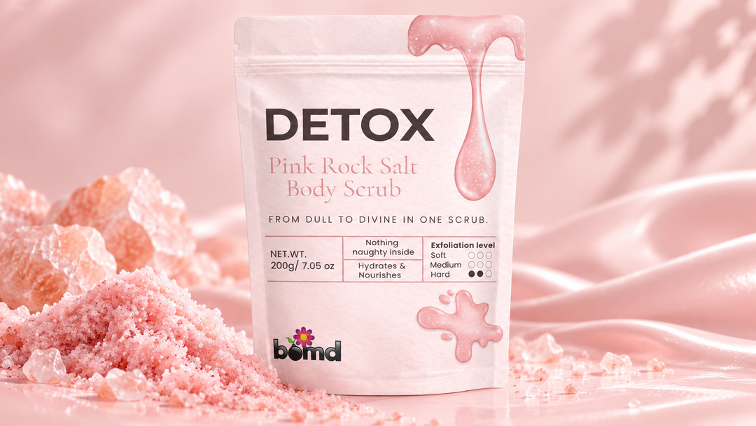 BOMD Detox Pink Rock Salt Body Scrub with pink salt crystals and scrub texture on a soft pink background